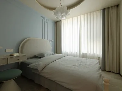 A modern bedroom with a fabric bed and curtains.