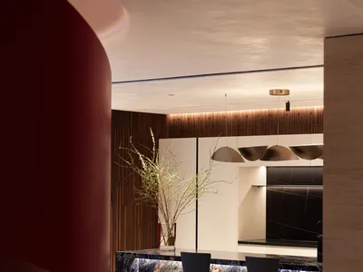 Modern kitchen with marble countertops, pendant lights, and seating area
