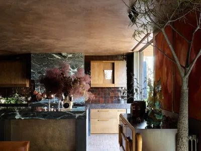 Modern residential kitchen featuring a marble countertop and wooden cabinets.