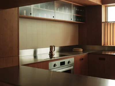 A modern kitchen with wooden countertops and tiled backsplash.