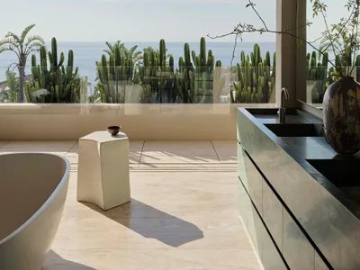 Modern minimalist bathroom featuring marble countertops, concrete walls, and ceramic tiling with a view of the ocean.