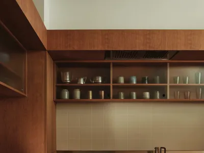 現代廚房搭配木質櫥櫃與玻璃檯面，內建爐灶與烤箱。
