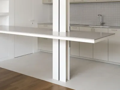 A minimalist white kitchen featuring metallic countertops.