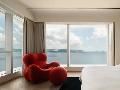 簡約臥室配有玻璃窗，可眺望海洋景色。