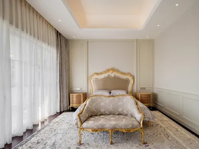 A classical bedroom featuring upholstered furniture and ornate details.