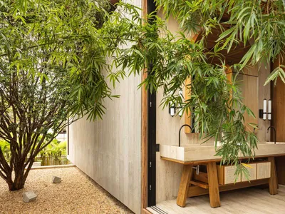 A modern bathroom featuring concrete walls and a wooden sink with a natural stone countertop.