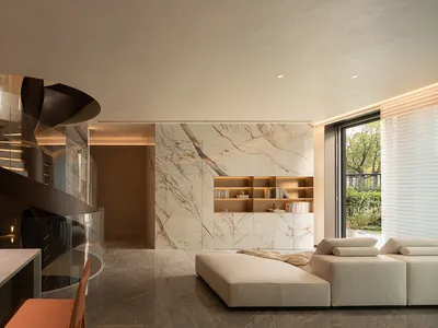 Modern residential space featuring a luxurious marble kitchen counter with a spiral staircase and a contemporary white sofa.