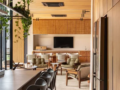 A modern bistro interior with a wooden counter, chairs, and a television in the background.