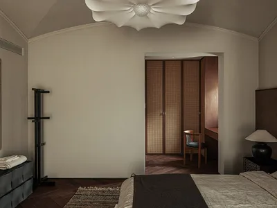 A bedroom that uses neutral colors, wood, leather, and fabric.