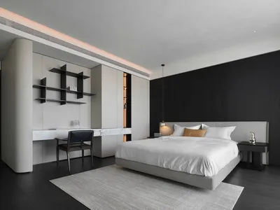 A minimalist bedroom with a bed, side table, and open closet.