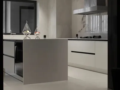 A modern kitchen with marble countertops and stainless steel appliances.