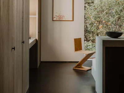 A minimalist residential kitchen featuring wood and concrete materials.