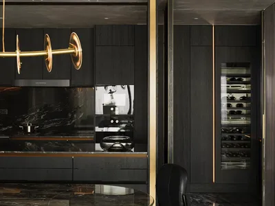 Modern luxury kitchen with black marble countertops, black and gold cabinetry, and minimalist design