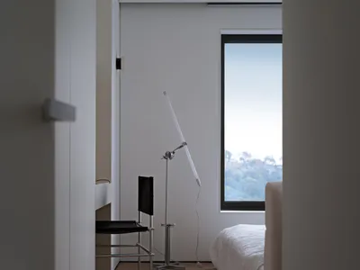 A minimalist bedroom with a wooden floor and a large window.