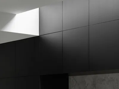 Modern minimalist kitchen featuring concrete countertops and marble backsplash
