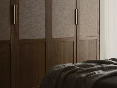 A minimalist bedroom featuring dark walls, wood detailing, and fabric textiles