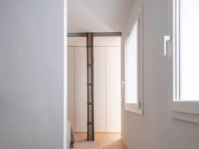 Minimalist bedroom featuring wood flooring and wooden furniture.