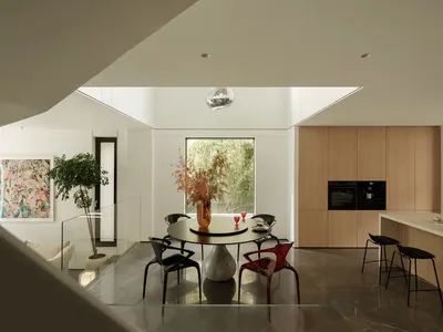 A modern kitchen with marble countertops, glass decor, and botanical elements.