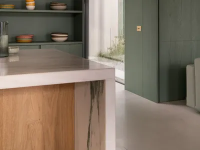 A modern kitchen interior with white marble countertops and wooden accents
