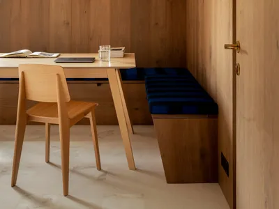 A modern home office with a wooden desk and chair.