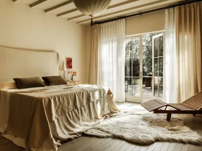 A minimalist bedroom featuring warm, natural fabrics and soft, neutral tones.