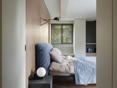 A minimalist bedroom with a bed, pillows, and a window with blinds.