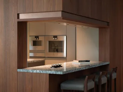 Modern kitchen featuring a marble bar counter with stools and a sleek interior design.