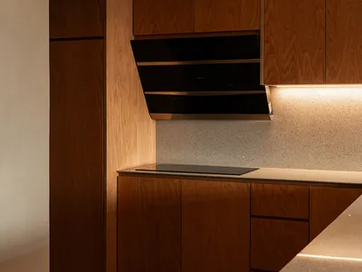 A modern kitchen with wooden cabinets and a sleek, minimalist design.