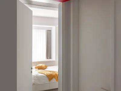 Minimalist bedroom featuring colorful decorative trims on the ceiling.