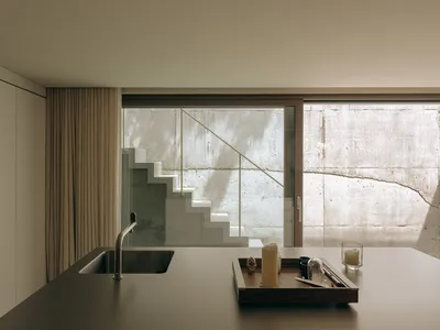 A modern, minimalist residential kitchen featuring concrete elements.