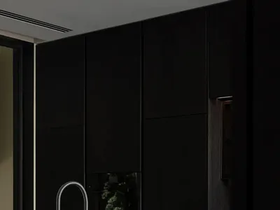 A modern minimalist kitchen with black cabinets, stainless steel appliances, and a black countertop with metallic accents.