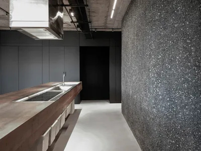 Modern minimalist kitchen with concrete countertop, featuring sleek, clean lines and a monochromatic color palette.