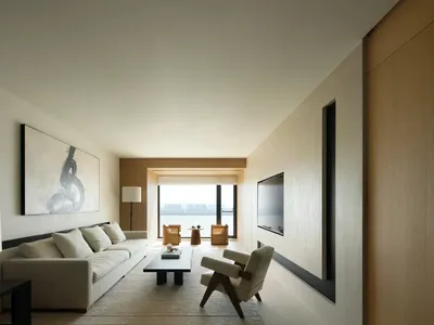 Modern minimalist living room featuring a long white sofa, a low black and white coffee table, two wooden armchairs, and a sl