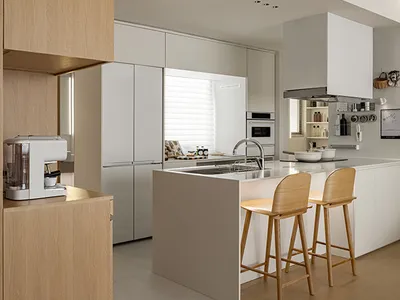 開放式住宅廚房，採用簡約設計，搭配白色櫥櫃，無明顯雜物。