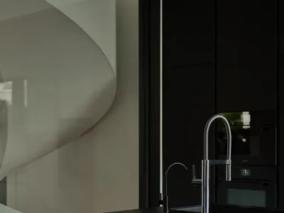 Modern kitchen with metallic fixtures and white wall