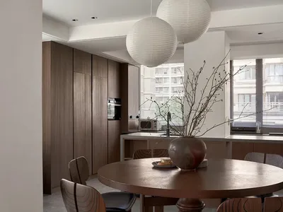 Modern kitchen with wooden furniture and a plant on the dining table.