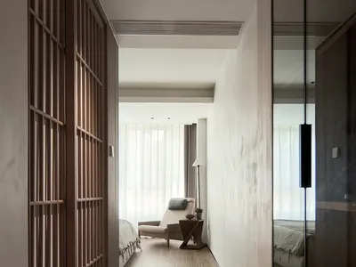 Modern minimalist bedroom featuring a glass window and furniture with neutral tones