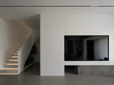 A contemporary minimalist living room with a concrete floor and modern design elements.