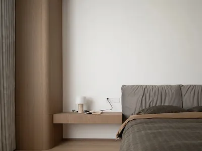 Minimalist bedroom with a floating nightstand, upholstered bed, and wood elements.