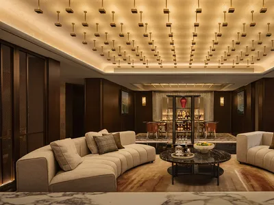 A luxurious hotel reception room featuring modern leather sofas, marble accents, and a sophisticated lighting design.