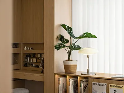 A minimalist bedroom featuring wood elements and a potted plant.