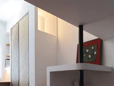 A minimalist bedroom with wooden shelves, metal accents, and a wooden bed frame.