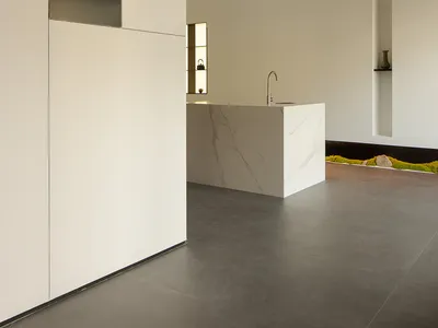 Modern kitchen with white marble countertops and white cabinetry.