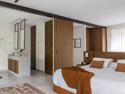 A modern minimalist bedroom featuring wooden accents and a cozy atmosphere