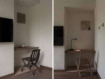 A minimalist home office with a wooden desk, chair, and wall-mounted television.