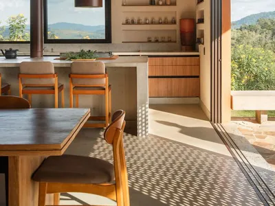 A modern minimalist kitchen with concrete walls and wooden furniture.
