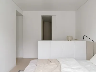 現代簡約臥室，搭配白色床組與木質地板。