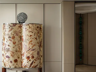 A fabric curtain in a living room with a pattern of wildflowers.