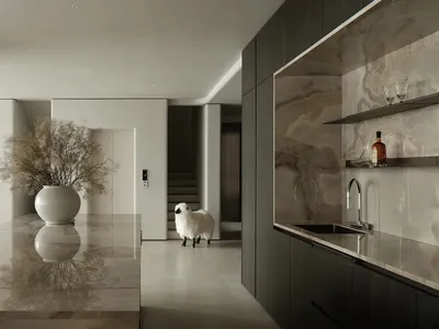 Modern kitchen featuring marble countertops and backsplash, with a large vase of flowers and a sheep figurine.