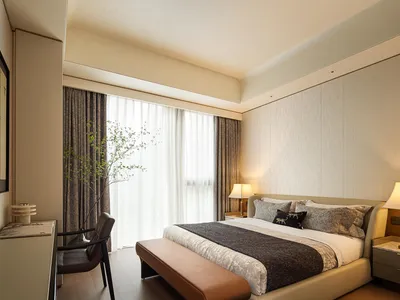 A modern bedroom with fabric finishes and a large window.
